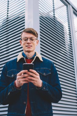 Başarılı hipster blogger sırasında kolay mesajlaşma Smartphone cep telefonu ile sosyal ağlar gülüyor 4 internet'e bağlı. Güncelleştirme profil sayfası telefon ayakta kentsel ortamda pozitif genç adam