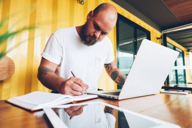 Ciddi bin yıllık erkek öğrenci dizüstü bilgisayar ve wifi college Kampüsü, notlar üzerinde serbest çalışma makale yayın için yetenekli erkek blogger kullanarak ödev Not Defteri'nde yazma