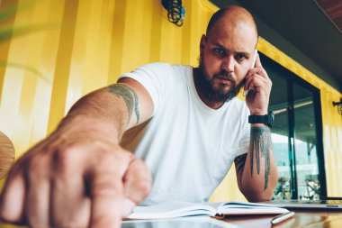 Başlangıç yazılım güncelleştirmesi için dijital tablet telefon ve basın güvenlik kodu konuşurken ciddi sakallı adam portresi, bin yıllık adam akıllı telefon konuşmayı unlock için ekrandaki parmak koymak