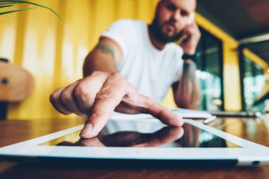 Kamera telefon görüşmesi ve tablet için yakınlaştırma dokunmadan bakarak ciddi sakallı adam portresi, yakışıklı adam güvenlik kodu girin Taşınabilir PC'de ofiste cep telefonu konuşma yaparken