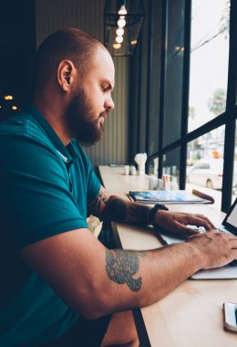 Uzak iş, konsantre adam bilgi online kurslar öğrenme e için arama netbook klavye için sahte ekran ve wifi kafeteryasında ile dizüstü bilgisayar kullanan yetenekli erkek serbest meslek