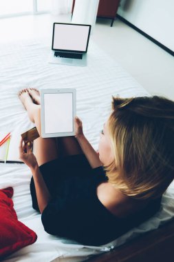 Genç bir kadının portatif bilgisayar uygulaması üzerinden kredi kartı kullanarak alışveriş yapmasının en üst görüntüsü, hippi kız tablet aracılığıyla web mağazasından alışveriş yapıyor ve web sayfasında yatmakta olan eşyalar için ödeme yapıyor.