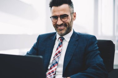 Yarım uzunluk portresi başarılı iş adamı orta yaşlı muhasebesi raporu, dizüstü bilgisayar üzerinde çalışan kablosuz 4 g için bağlıyken kameraya gülümseyen Internet. Posta kontrol müreffeh gurur ceo