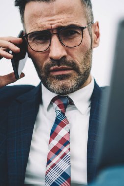 Kendine güvenen orta yarım uzunluk portre smartphone aygıtında çağrılırken kameraya bakarak girişimci yaşlı. Ciddi icra müdürü 50 yaşında elinde cep telefonu üzerinde konuşurken dokunmatik yüzey ile