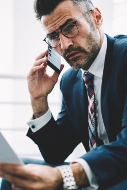 Ofiste çalışan Smartphone için işlecini çağırmak ellerinde mali metin raporlarla emin başarılı iş adamı. Gurur CEO'su 50 yaşında belgeler üzerinde telefon bankacılığı ile deneyimli