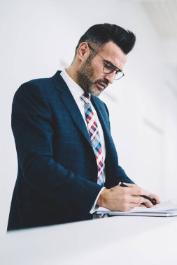 Dalgın olgun girişimci formal giyim ofis iç çalışma mali belgelerin incelenmesi giymiş. Bilgi okumada ve muhasebe raporları imzalama emin gurur CEO'su orta yaşları