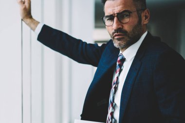 Kendine güvenen başarılı işadamı modern tablet aygıtı elinde tutan ve kameraya bakarak 50 yaşında yarım uzunluk portre. Finans şirketinin ciddi olgun sahibi formal giyim giyinmiş