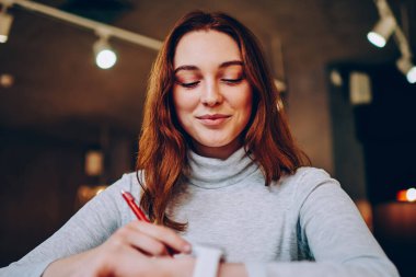 Genç bayan, modern giyilebilir cihazlardan memnun. Yeni mesajları kontrol ederken öğreniyor. Hippi kız, elektronik akıllı yalıtım üzerinde ödev yapmak için zaman ayırıyor.