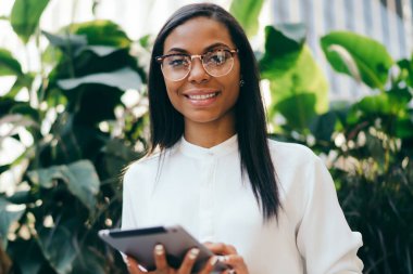 Başarılı koyu tenli kadın ofis çalışanı dijital dokunmatik ped cihaz üzerinde online ödeme yapmadan Eyewear portresi bağlı 4 g için Internet. Tablet ile müreffeh Afrikalı-Amerikalı genç kadın