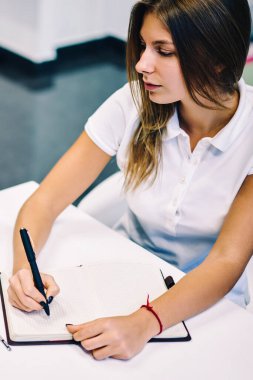 Dizüstü bilgisayar, dizüstü Gözat web sayfasında eğitim gözden film düzenleme yazı için yazılı yetenekli kız öğrenci online webinar seyrederken notlar yapma genç kadın konsantre