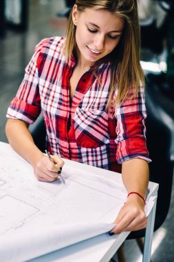 Kız öğrencinin ders planı accountings ile büyük iş memnun kontrol gülümseyerek olumlu yetenekli kadın mimar proje üzerinde çalışma süreci zevk kağıt üzerine çizim inşaat kroki