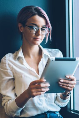 Çekici yetenekli kız öğrencinin eğitim webinar Web sitesinde dijital tablet içinde izlerken göz koruması için gözlük. Çok kadın blogger sosyal ağ dokunmatik yüzey üzerinde takipçileri ile sohbet