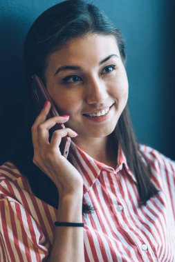 Portre resim güzel neşeli kadın Blogger cep üzerinden mobil konuşmayı şık gömlek giymiş. Sevimli gülümseyen hippi kız kapalı otururken modern smartphone konuşuyor