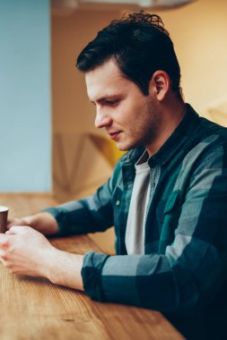 Yeni arkadaş ekleme ve takipçileri ile genç erkek sabah haber web sitesi üzerinden cep wifi kafede kullanarak okuma sohbet ara smartphone üzerinden ağ dalgın teen hipster adam