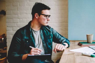 Dalgın hipster adam gözlük izlerken eğitim webinar e-öğrenme, proje için serbest tarama bilgilerini kroki çizim netbook üzerinde çalışan erkek tasarımcı üzerinde vakit dizüstü bilgisayar
