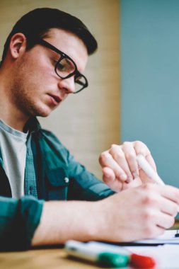 Dalgın zeki erkek öğrenci üniversitede, konsantre hipster adam kontrol zaman organizasyon öğrenme sürecinde üniversite sınavına hazırlık testi test yazma sırasında kol saati seyir