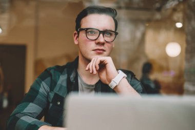 Ciddi erkek serbest meslek kafe iç, dizüstü bilgisayarda çalışma işlemi sırasında durulması gözlük netbook çevrimiçi eğitim yakın oturan çözümleri hakkında düşünme düşünce hipster adam