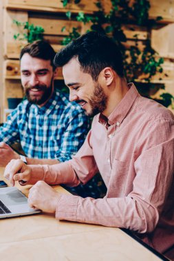 Öğrenme ve ödev college Kampüsü, içinde birlikte müreffeh erkek programları ile araçlar coworking'da oturan iş fikirleri tartışmak için modern dijital cihazlar kullanılarak hipster çocuklar gülümseyen