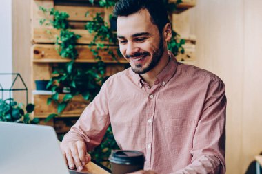 Kampüs coffet Kupası ile dinlenme dizüstü bilgisayar arkadaş genç öğrenci zevk sohbet gülümseyen, müreffeh erkek serbest meslek sahibi netbook yeni app indirme uzaktan çalışma ile memnun