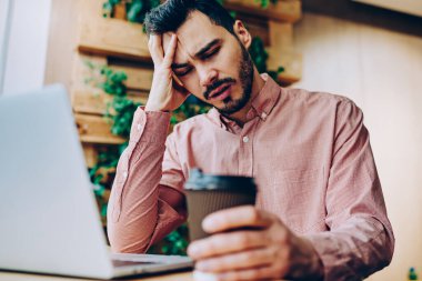 Kapalı gözlü, yorgun ve üzgün bir erkek öğrenci. Sınavlara hazırlanma sorunları yüzünden üzgün. Aşırı çalışan hippi çocuk çalışma alanında fazla çalışıyor.