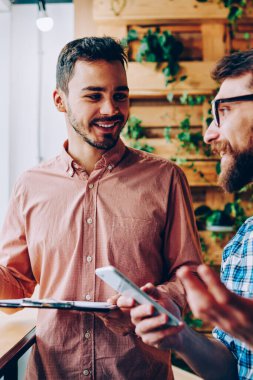 İş planı için birlikte tartışmaya başarılı erkek startuppers gülümseyen ve mimik, iş bilgileri office coworking toplantısı hakkında samimi konuşmayı mutlu hipster çocuklar