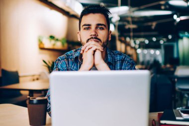 Dizüstü bilgisayarın başında oturmuş sınav sonuçlarını bekleyen endişeli genç hipster adamın portresi, erkek serbest yazar, birlikte çalışma ofisindeki görevi tamamlamaya odaklanmış çözümler üzerinde kafa yoruyordu.