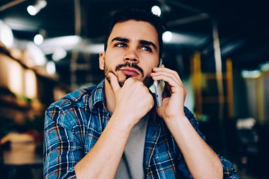 Düşünceli hippi adam, kafede arkadaşlarıyla telefonda konuşurken, cep telefonundan müşteri destek hattıyla bağlantı kurmayı bekleyen düşünceli bir genç adamla buluşmayı düşünüyor.