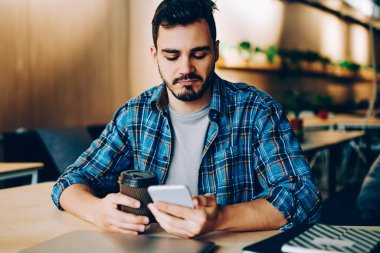 Dalgın genç adam dostları Güncellenme Zamanı kontrol n sosyal ağlar üzerinden cep kahve molası sırasında tarama hipster adam video online eğlence sırasında izlemek için telefon üzerinde düşünme profilleri