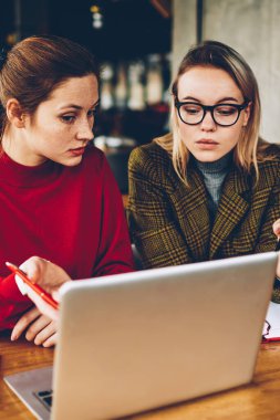 Ayrıntılar teamworking modern dizüstü bilgisayar, tartışırken iki profesyonel grafik tasarımcıları. Yetenekli öğrenciler Webinar online yolu ile 4 g netbook üzerinde izlerken internet ve fikirler işbirliği sırasında analiz