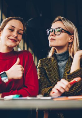 İşaret gibi gösteren ve kamera rüya gibi sarışın arkadaş Üniversitesi'nde masada oturan planları hakkında gözlük düşüncesinde ise gülüp başparmak ile mutlu esmer öğrenci portresi yarım uzunluk