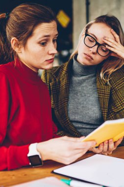 Karışık yetenekli öğrenciler ders kitabı bilgi alan coworking içinde sınava hazırlık sırasında merak. Eğitim materyali birlikte edebiyat kitap okuyan analiz sinirli hipster kızlar