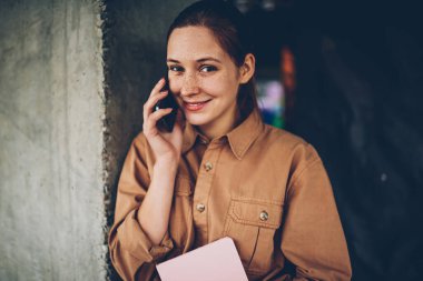 İstek-e doğru Smartphone cep telefonu ile arkadaş süre kamera gülümseyen pozitif genç kadın yarım uzunluk portre. Telefonda konuşmayı şirin neşeli öğrenci. Cep üzerinde konuşmak mutlu hippi kız