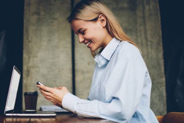 Mutlu hipster smartphone aygıt takipçileri ile blogger online sohbet yan görünümü bağlı 4 g ağlarda mesajlaşma space.positive öğrenci coworking içinde modern netbook oturan internet