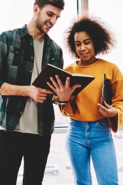 İyi görünümlü kırpılmış görüntü gülümseyen adam ve büyüleyici pozitif kadın birlikte beyin fırtınası sırasında eğlenmek sakallı. Başarılı erkek ve dişi pencere karşı ayakta birbirleri ile iletişim