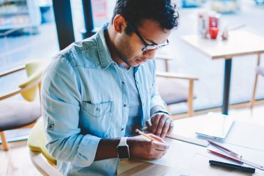 Kırpılmış görüntü akıllı yetenekli erkek mimar çizimler yeni bina projesi için çizim trendy kot elbise giymiş. Zeki işadamı kalem ve kural kullanarak başlangıç oluşturma gözlük