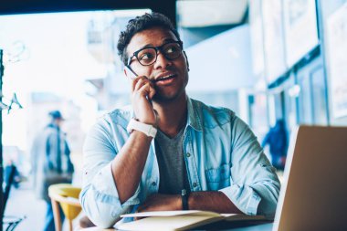 Olgun yakışıklı olumlu hindu girişimci havalı gözlükler müşteri yolu ile wifi için bağlı Smartphone uygulama ile iletişim içinde. Cep telefonu kapalı arkadaşlarınızla konuşurken iyi görünümlü adam