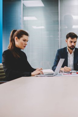 Dalgın iki profesyonel finans şirketi patronla tablo toplantıda çalışma brifing sırasında dizüstü bilgisayarlarda bilgi aramak. Gurur CEO'su posta smartphone meslektaşları ile işbirliği üzerinde kontrol