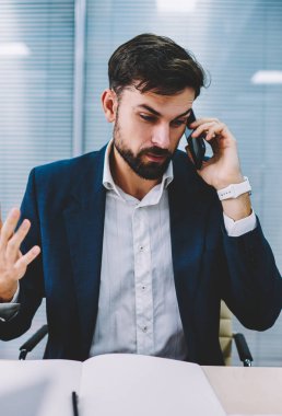 Öfkeli işadamı el eller ve smartphone için işlecini çağırmak çözme bankacılık sorunu. Telefon görüşmesi sırasında cep üzerinde çalışma sırasında office savunarak kızgın icra müdürü