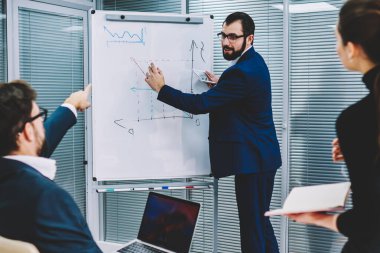 Flip grafik yanında duran ve ortakları için grafik çizim gözlük akıllı executive CEO'su sakallı. Erkek ve kadın yetenekli tüccarlar office işbirliği sırasında yeni fikirler tartışıyor