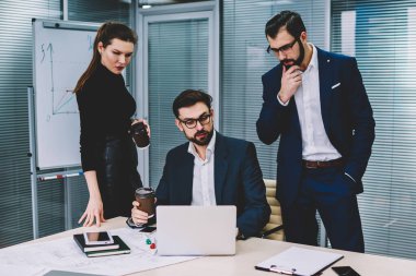 Yararlı bilgiler web sitesinde modern ofisinde oturum beyin fırtınası sırasında Internet'e bağlı dizüstü bilgisayar arama formal giyim grup yetenekli durulması hesap tüccarların giymiş