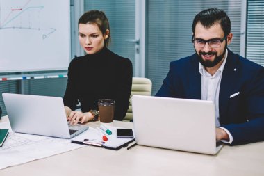 Grup olumlu deneyimli mimar dizüstü bilgisayarlar için wifi bağlı web sitelerinde araştırmalar yapma resmi elbise giymiş. Birlikte ofisinde çalışan yetenekli erkek ve kadın işçilerin