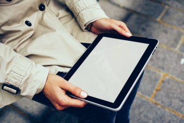 Erkek kırpılmış görünümünü holding dijital dokunmatik ped cihaz ile kopya alanı göstermek için Web sitenizin içeriği ve 4 g internet bağlantısı açık havada oturma ile uygulama yükleme eller