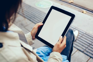 Genç kadının kırpılmış görünümünü holding dijital tablet cihaz sahte ekran üzerinde alanı ile Web sitenizin içeriği için eller. Hippi kız alan boş ekran üzerinde reklam ile modern dokunmatik yüzey ile