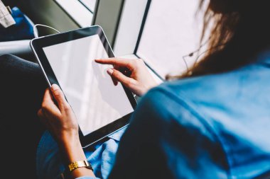 Touchpad ekranında dokunmatik kadın görüntüsü çevrimiçi uygulama kullanarak otobüs içinde otururken, portatif bilgisayardaki kadın kitap okurken toplu taşımacılıktaki kablosuz bağlantıyı kullanarak arka plan görüntüsü