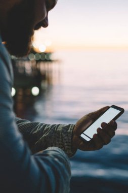 Cep telefonunda mesaj okurken gülümseyen olumlu adamın görüntüsü ekran görüntüsü açık havada duruyor, internette sohbet için dolaşırken 4G internet bağlantısından memnun gülümseyen adam.