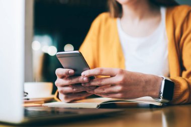 Ellerinde cep telefonu olan, başvuru yoluyla mesaj yazan ve başvuru yoluyla mesaj yazan kadın ellerine odaklan. Kafeteryada dinlenen akıllı telefon aygıtıyla arkadaşından e-posta okuyan beyaz bir kadın.