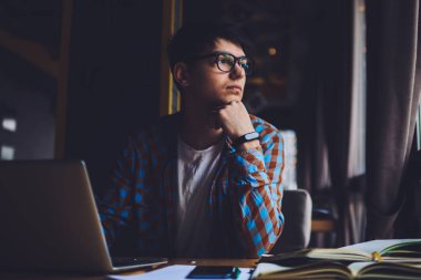 Düşünceli yaratıcı tasarımcı, modern dizüstü bilgisayarın başında oturan ve kablosuz internete bağlanan dul kadına bakıyor. Gözlükçü dükkanında çalışan düşünceli bir bilişim uzmanı.