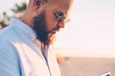 Mobil telefon Web sitesi üzerinden uygulama, rezervasyon yapma sakallı hippi adam yakın çekim gencin sosyal ağlarda şehir sokak arkadaş sohbet akıllı telefon kısa mesajla gönderme