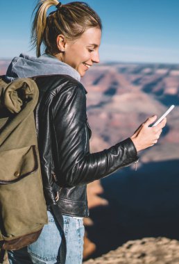 İyi mobil bağlantı, gülümseyen kadın Gezgin dağlarda macera gezisi sırasında uygulama denetimi kullanan tur Büyük Kanyon hiking sırasında telefonda kısa mesaj gönderme olumlu hippi kız