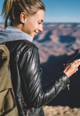 Sırt çantası bloglama iyi mobil bağlantı arizona Milli Parkı, hippi kız kontrol posta sırt çantası taşıyan vahşi doğada hiking Smartphone kullanarak ağlar ile kadın turist gülümseyen